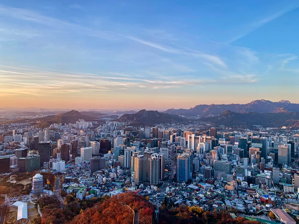 Seoul skyline beneath a pastel sunset sky