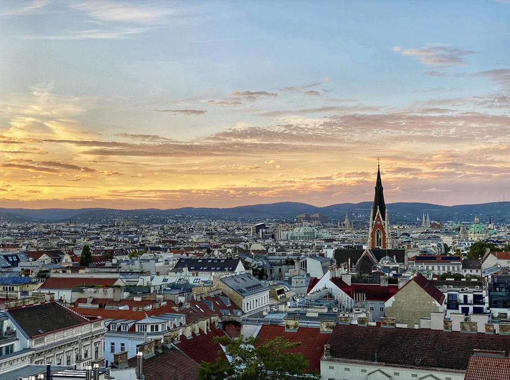 Vienna skyline and rooftops beneath a golden evening sky